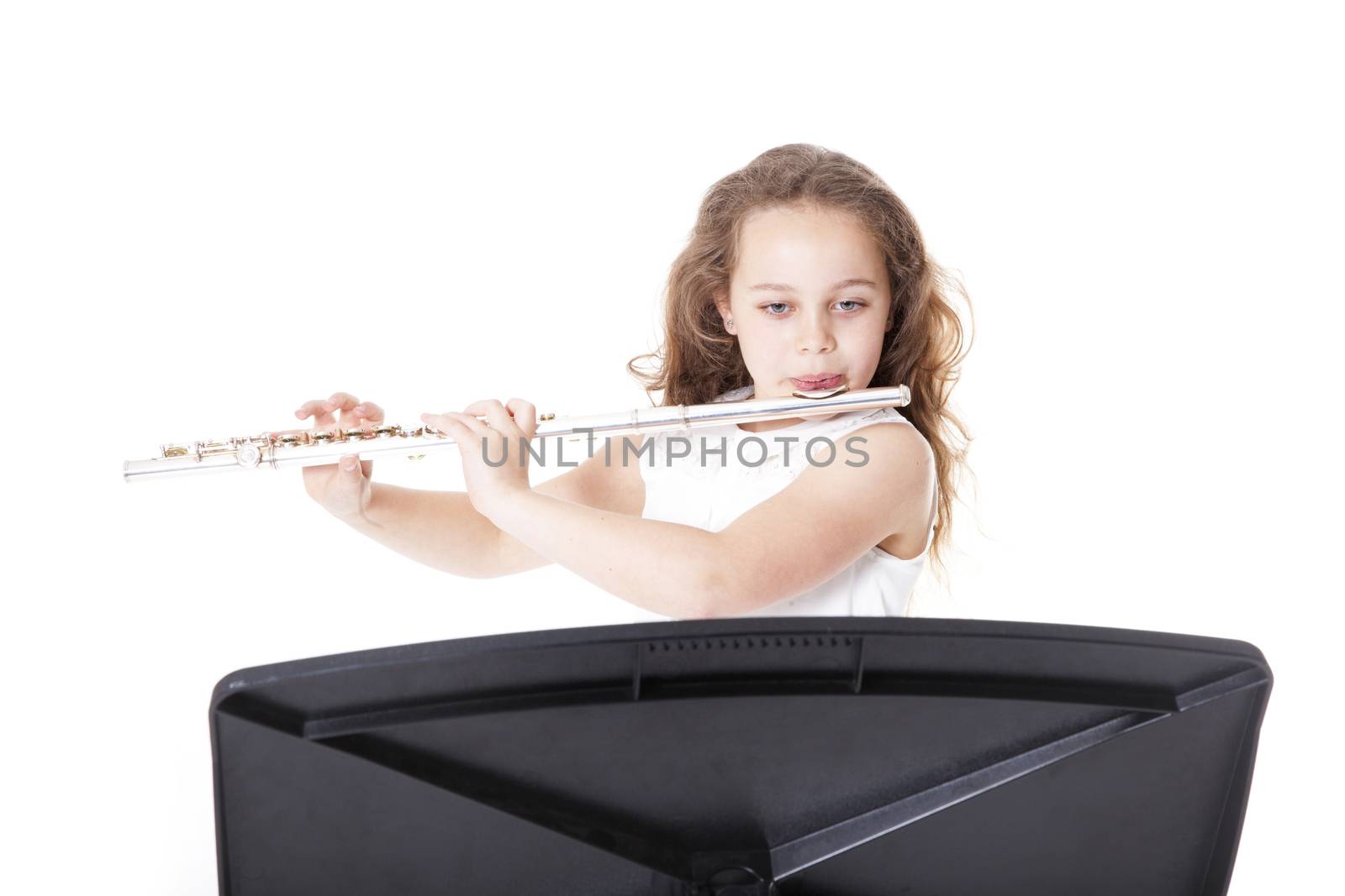 young girl playing flute against white background in studio