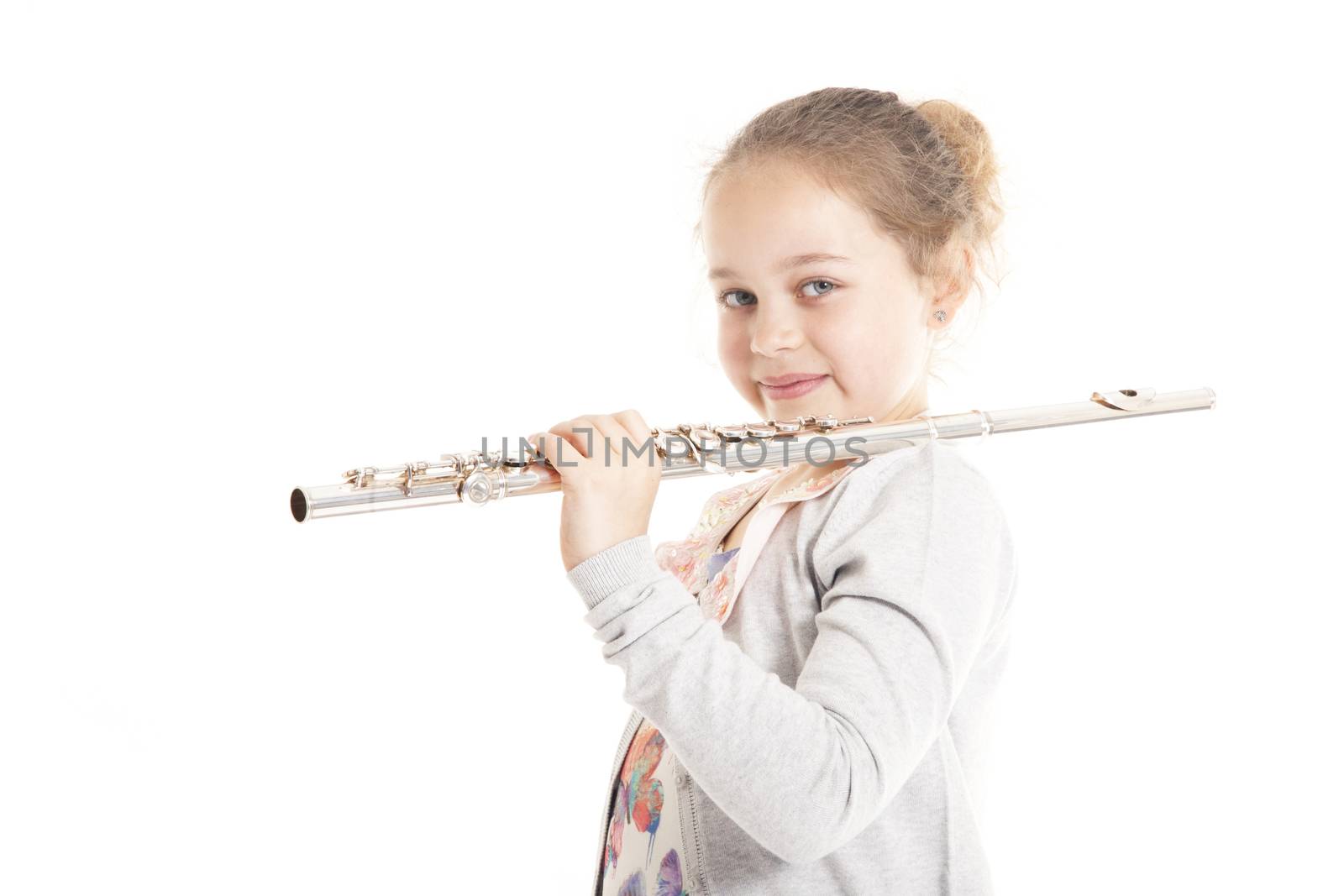 young girl holding flute against white background in studio