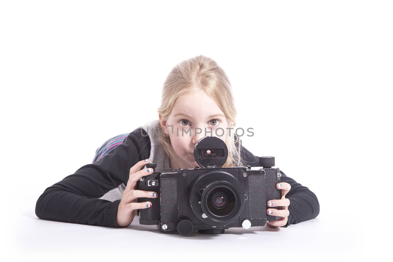 young girl with large old fashioned camera in studio against white background
