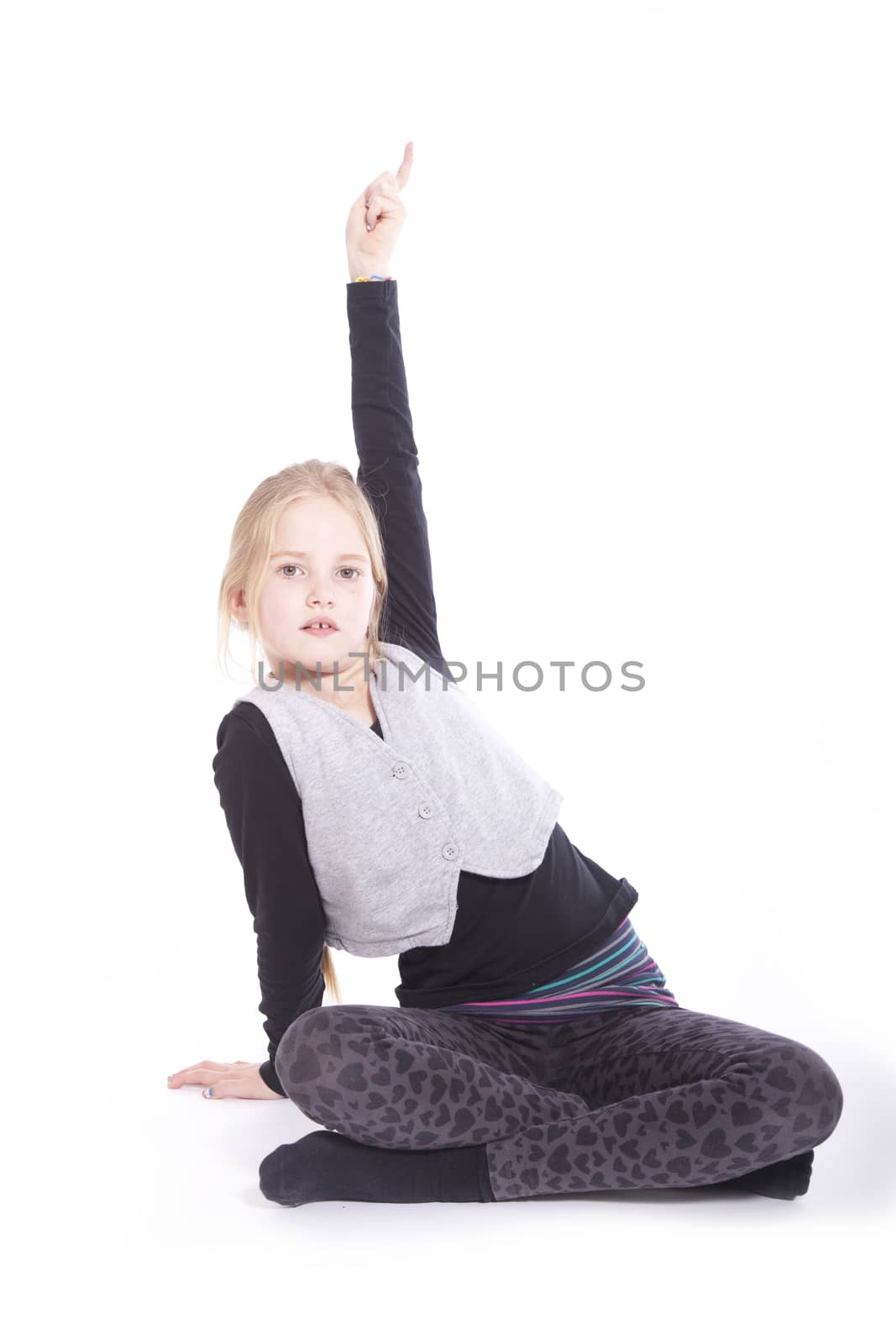 young sitting girl raising her finger to get attention in studio against white background