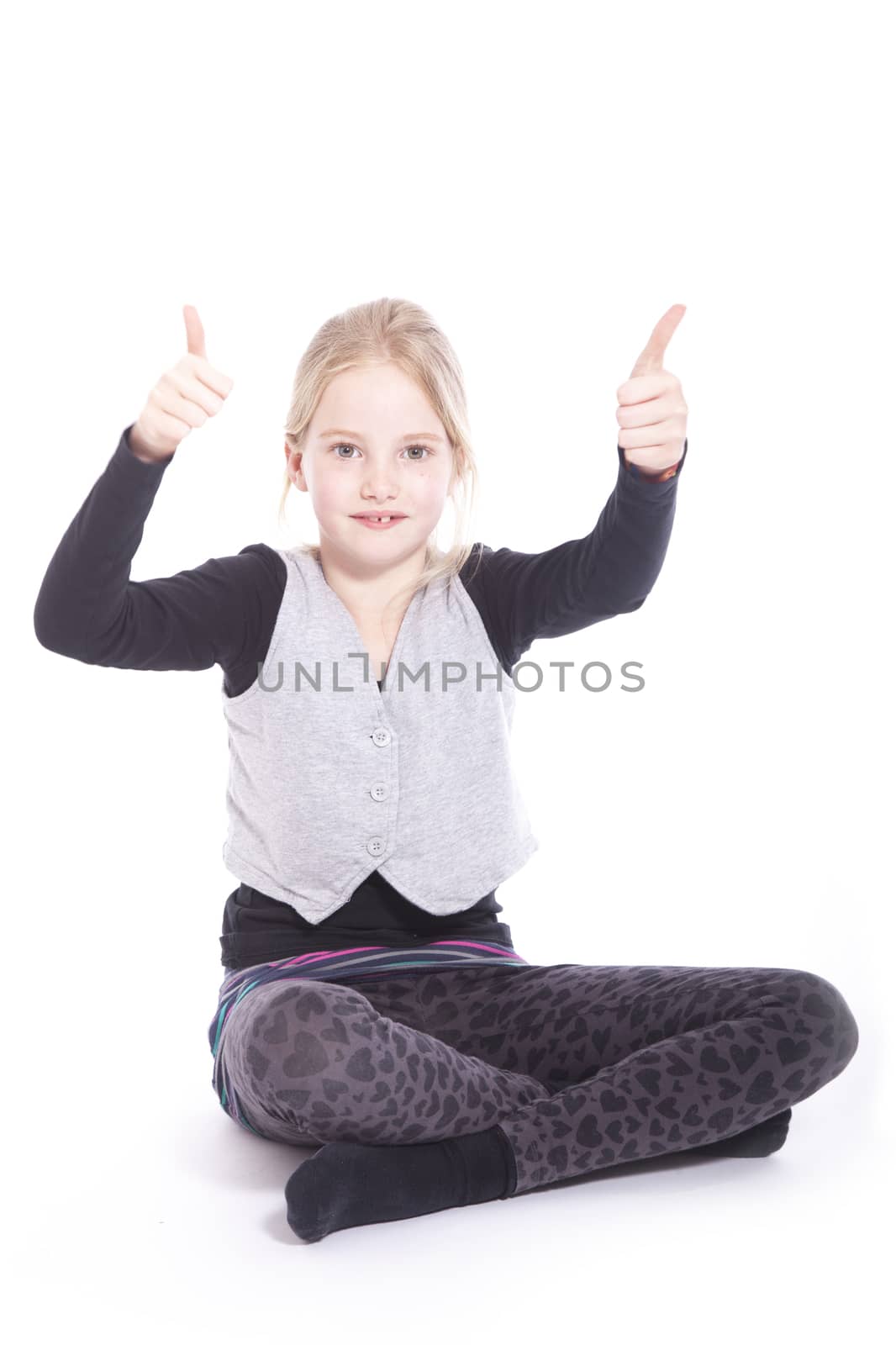 young girl in studio with both thumbs up against white background