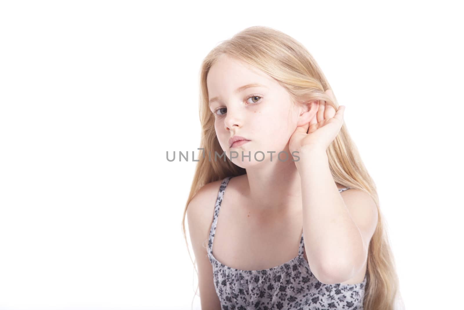 young girl making hearing gesture in studio against white background