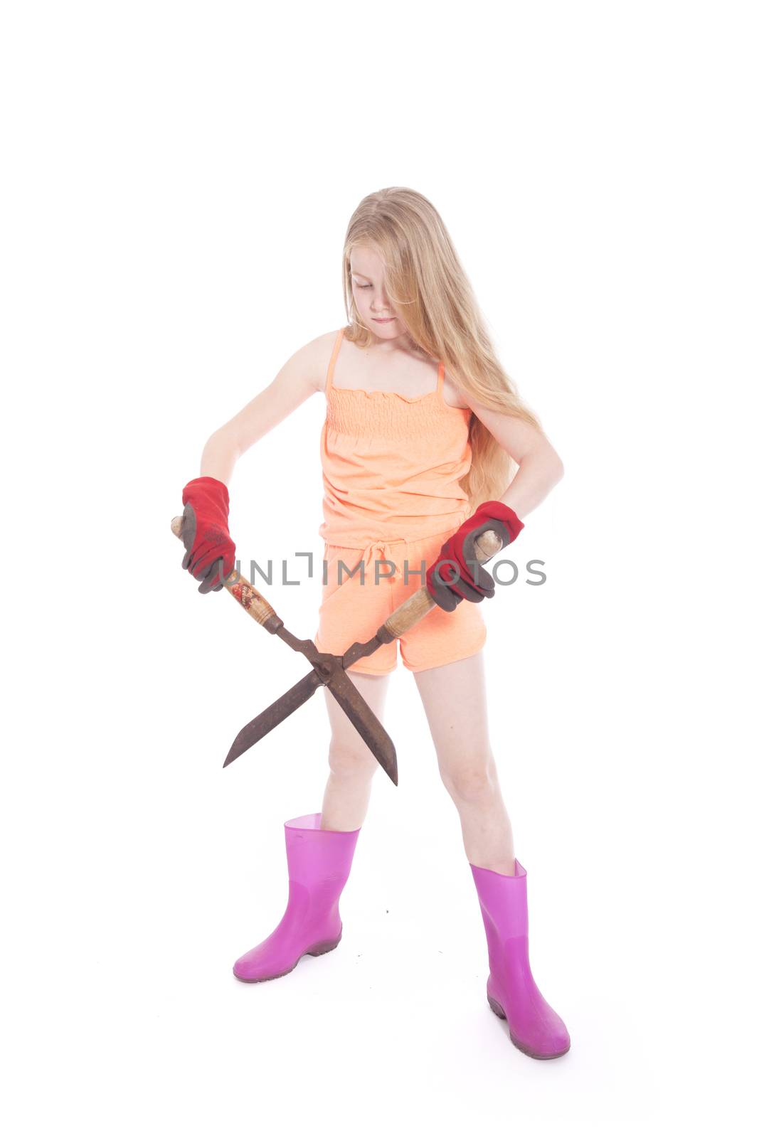 young blond girl with garden shears in studio against white background