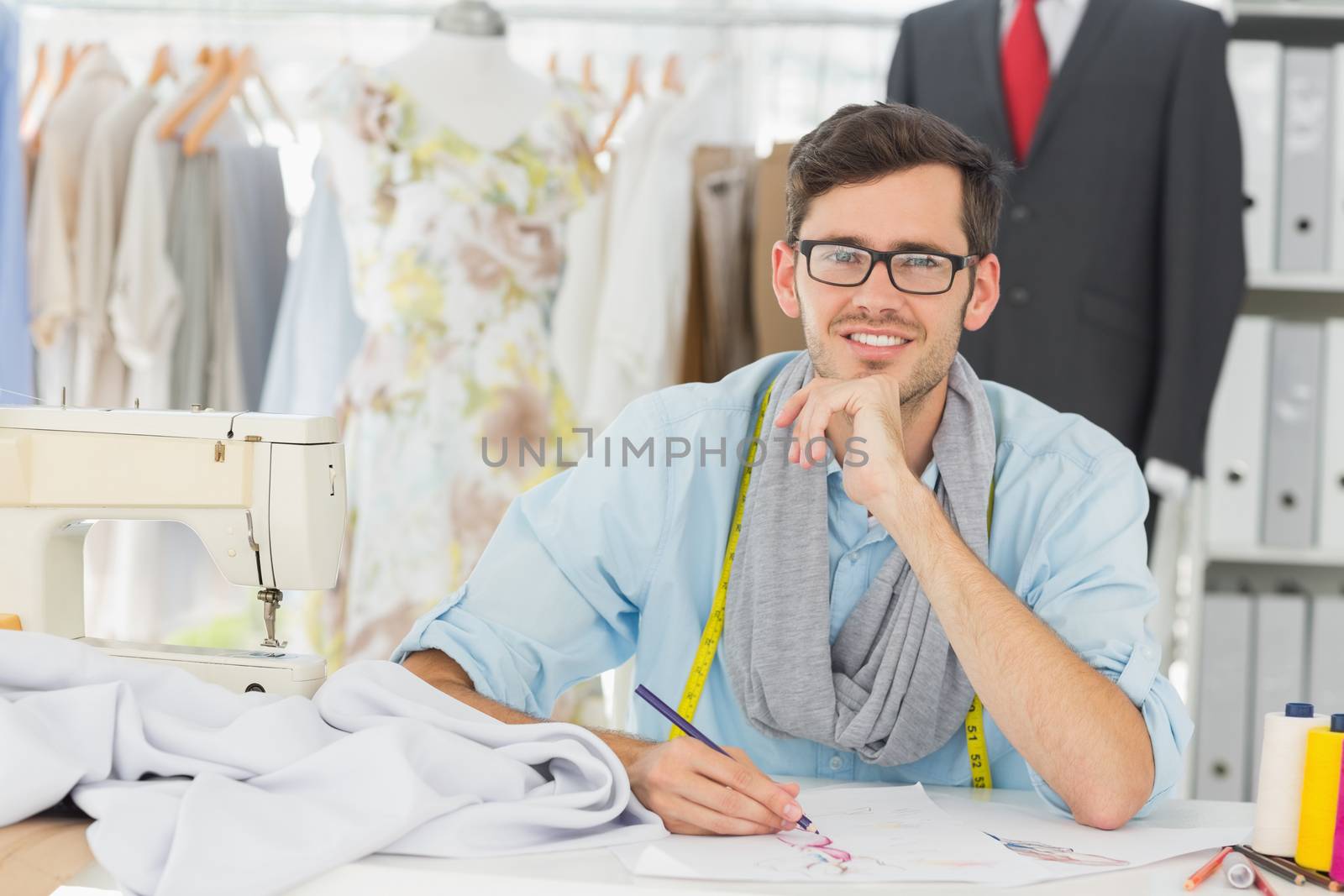 Young male fashion designer working on his designs in the studio