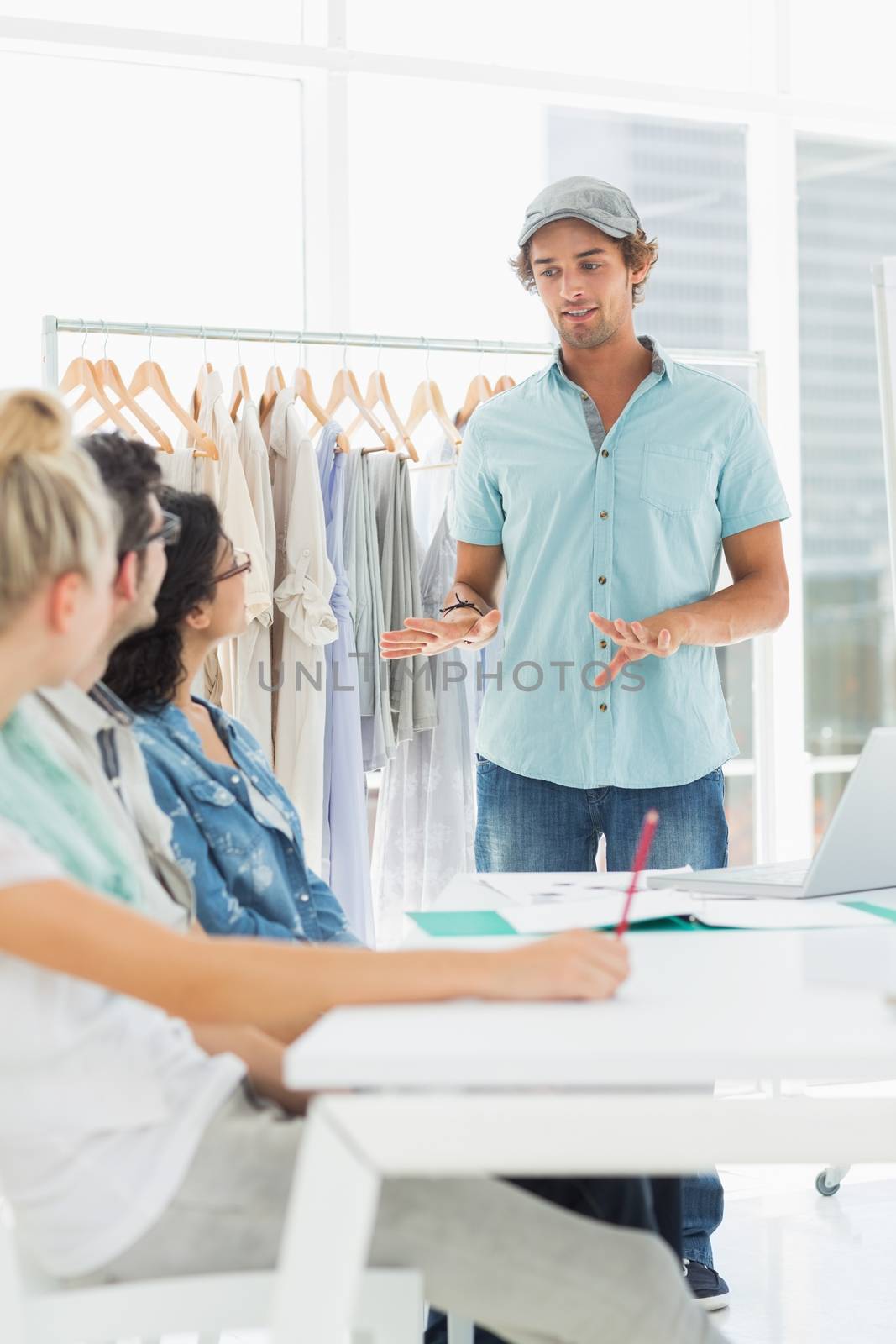 Group of fashion designers discussing designs in a studio