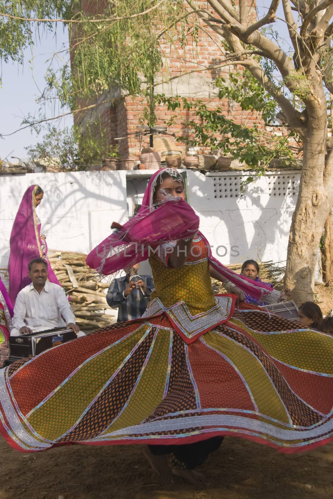 Beautiful tribal dancer in colorful costume performing in Jaipur, Rajasthan, India