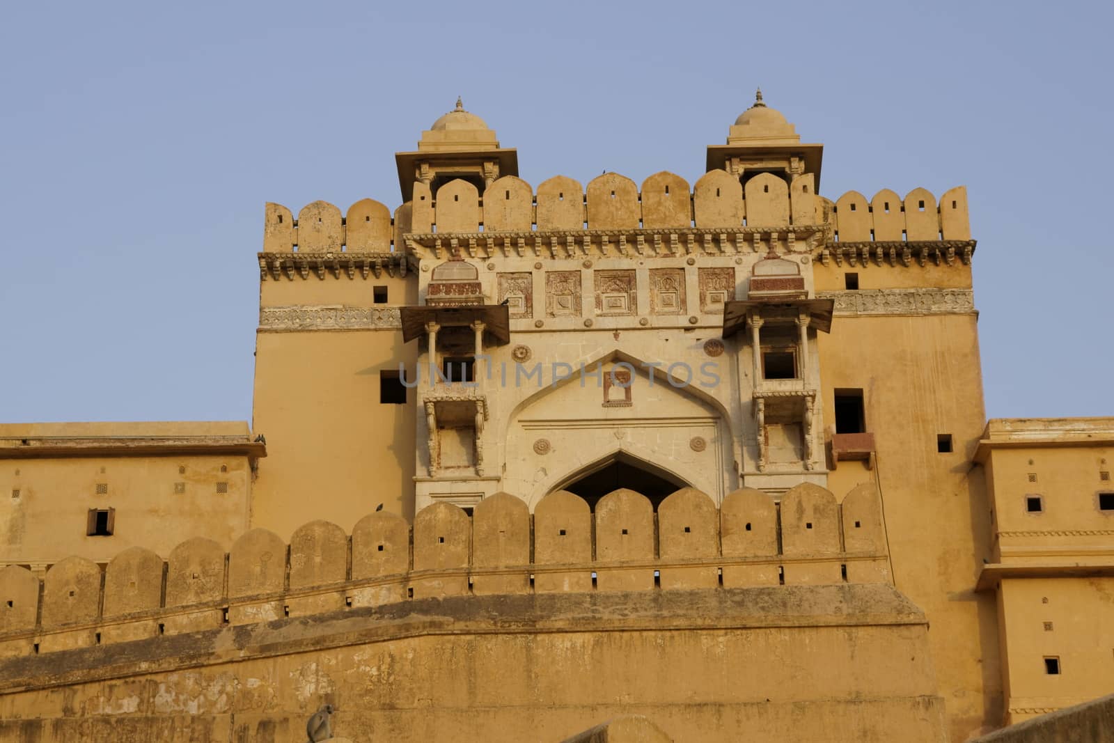 Imposing front entrance (Suraj Pol) to Amber Fort. Large honey coloured Moghul style building. Jaipur, Rajasthan, India