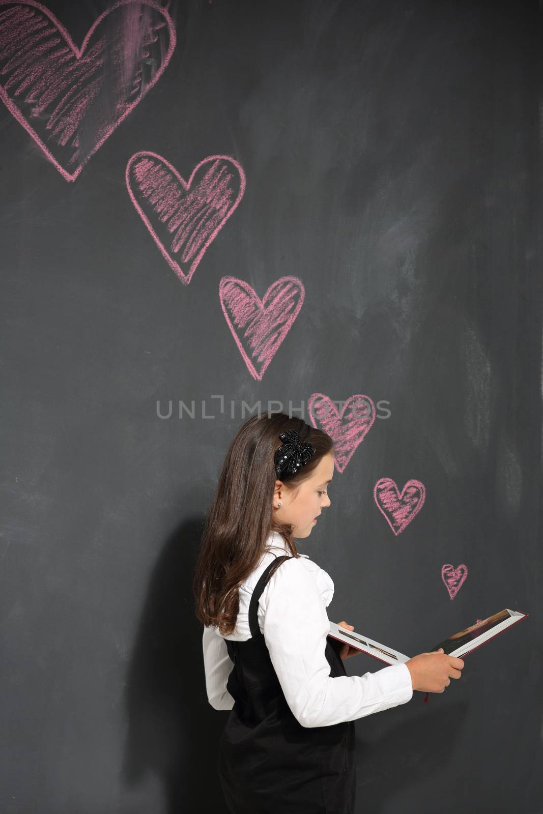 Girl in school uniform on a black background plate