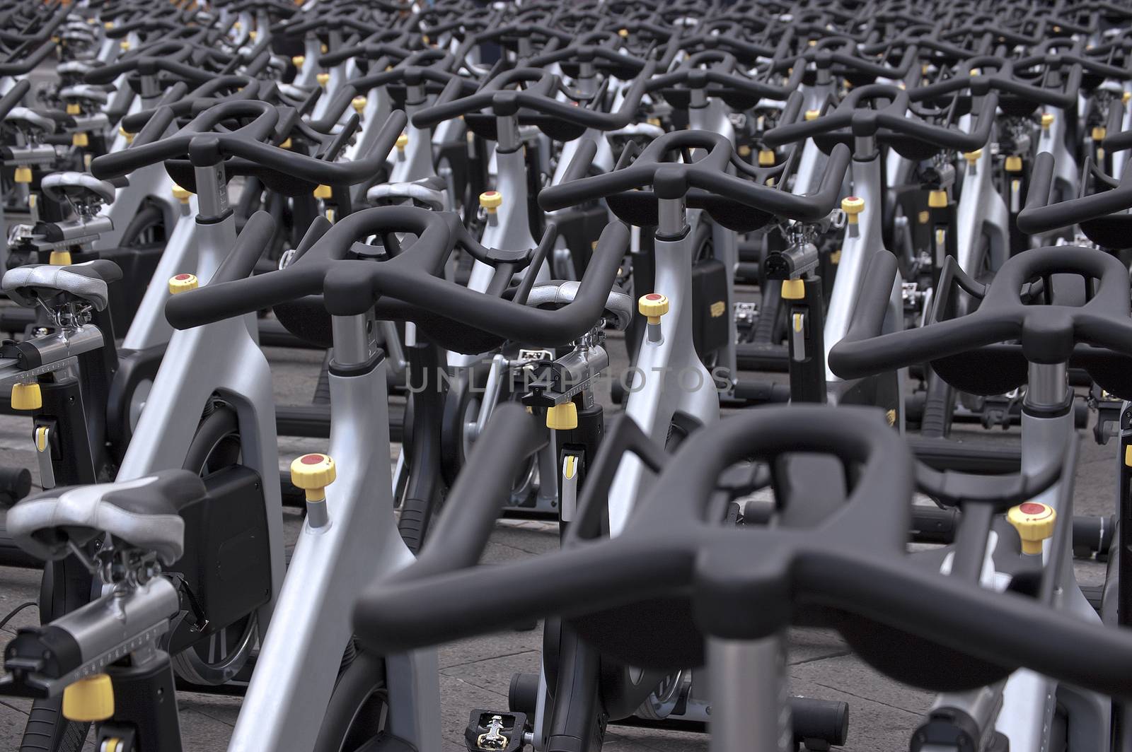 Large group of aluminum exercise bikes outdoors