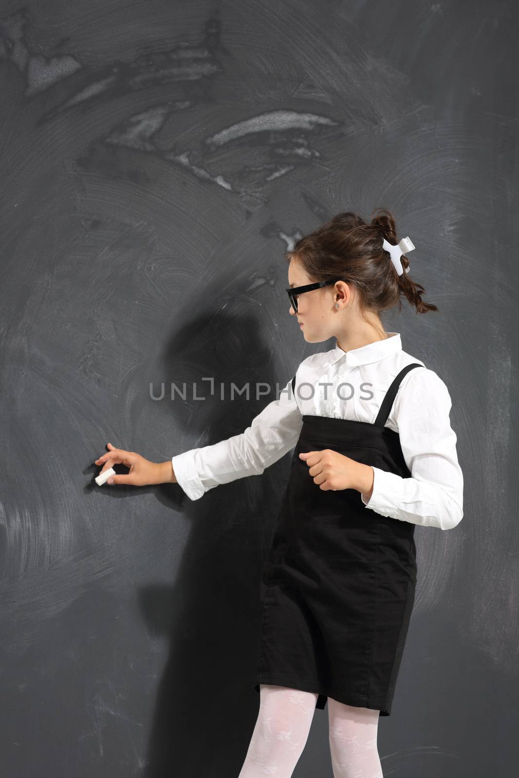 schoolgirl writes on the blackboard . by robert_przybysz