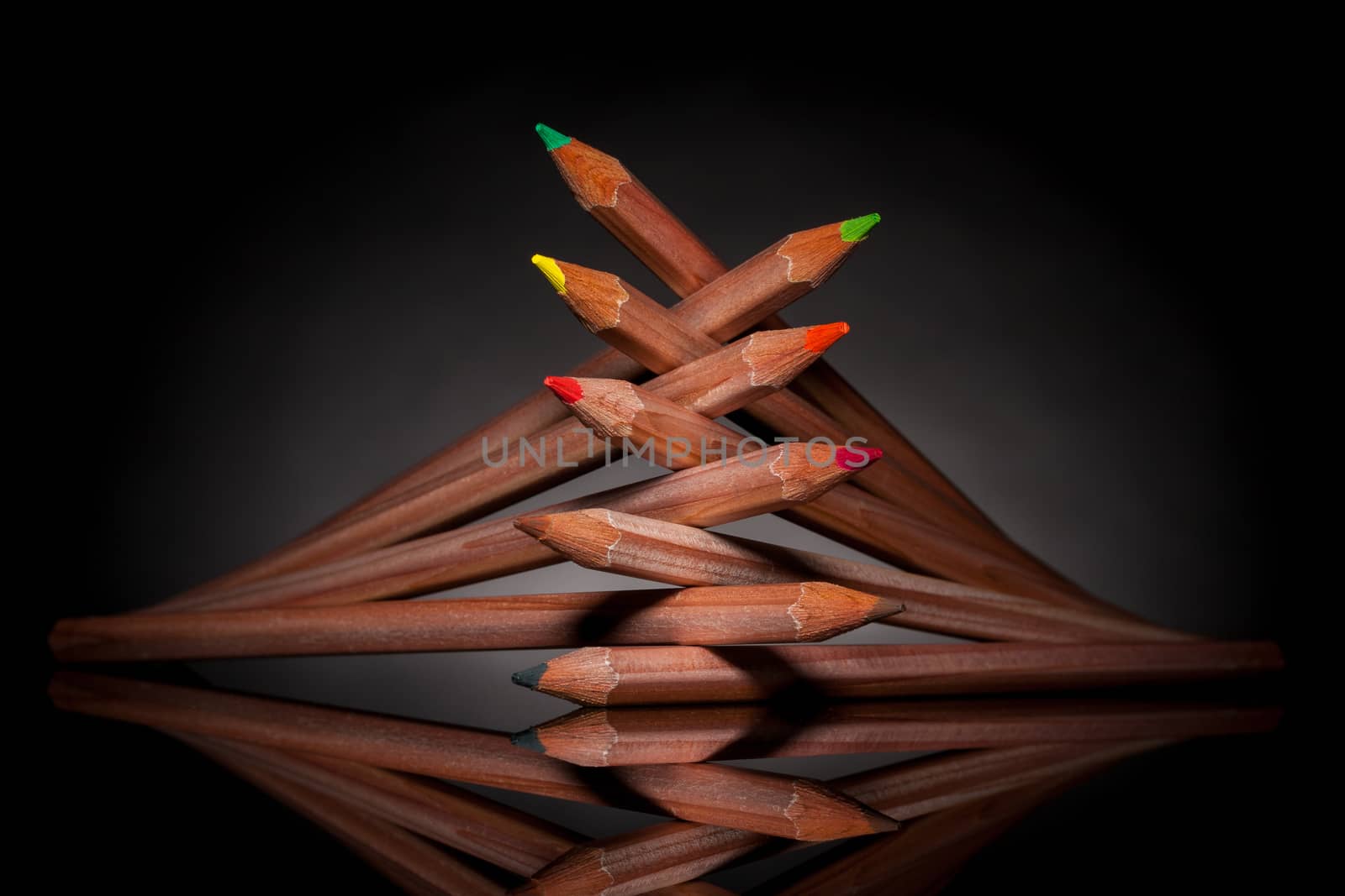 creatively stacked pencils of different colors with backlight