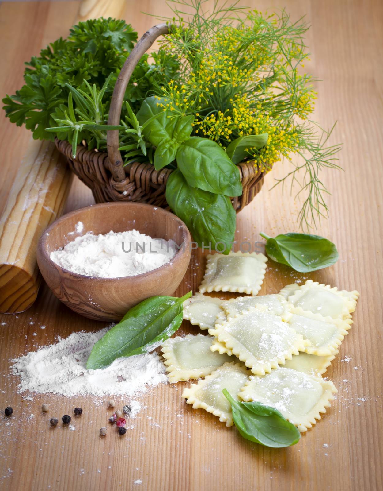 Homemade pasta ravioli with fresh basil, on wooden background