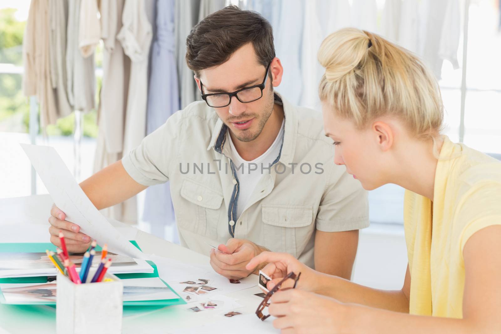 Two fashion designers discussing designs in a studio