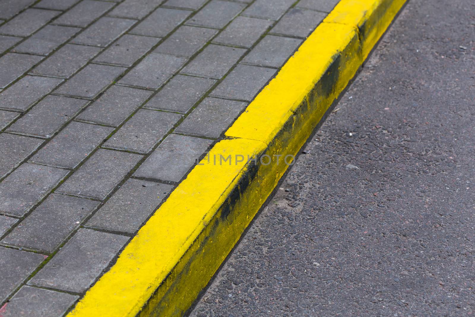 Yellow kerb line on the asphalt proad
