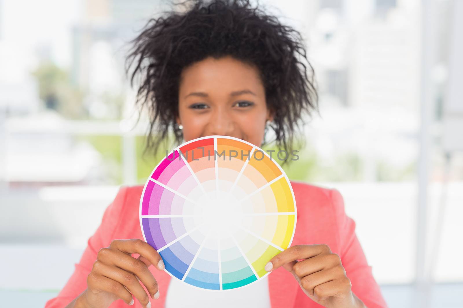 Portrait of a beautiful young woman holding color wheel at bright office