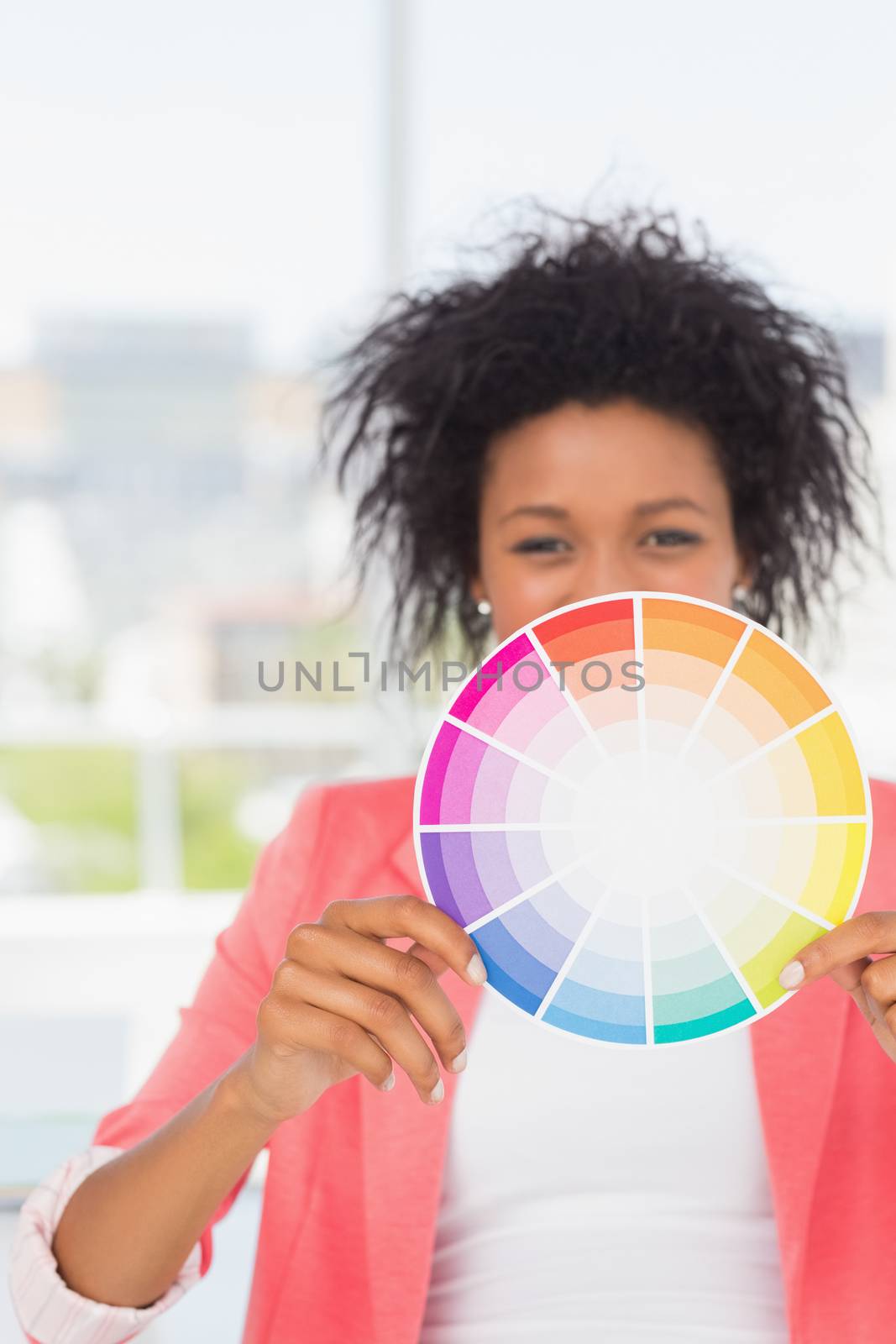 Beautiful young woman holding color wheel by Wavebreakmedia