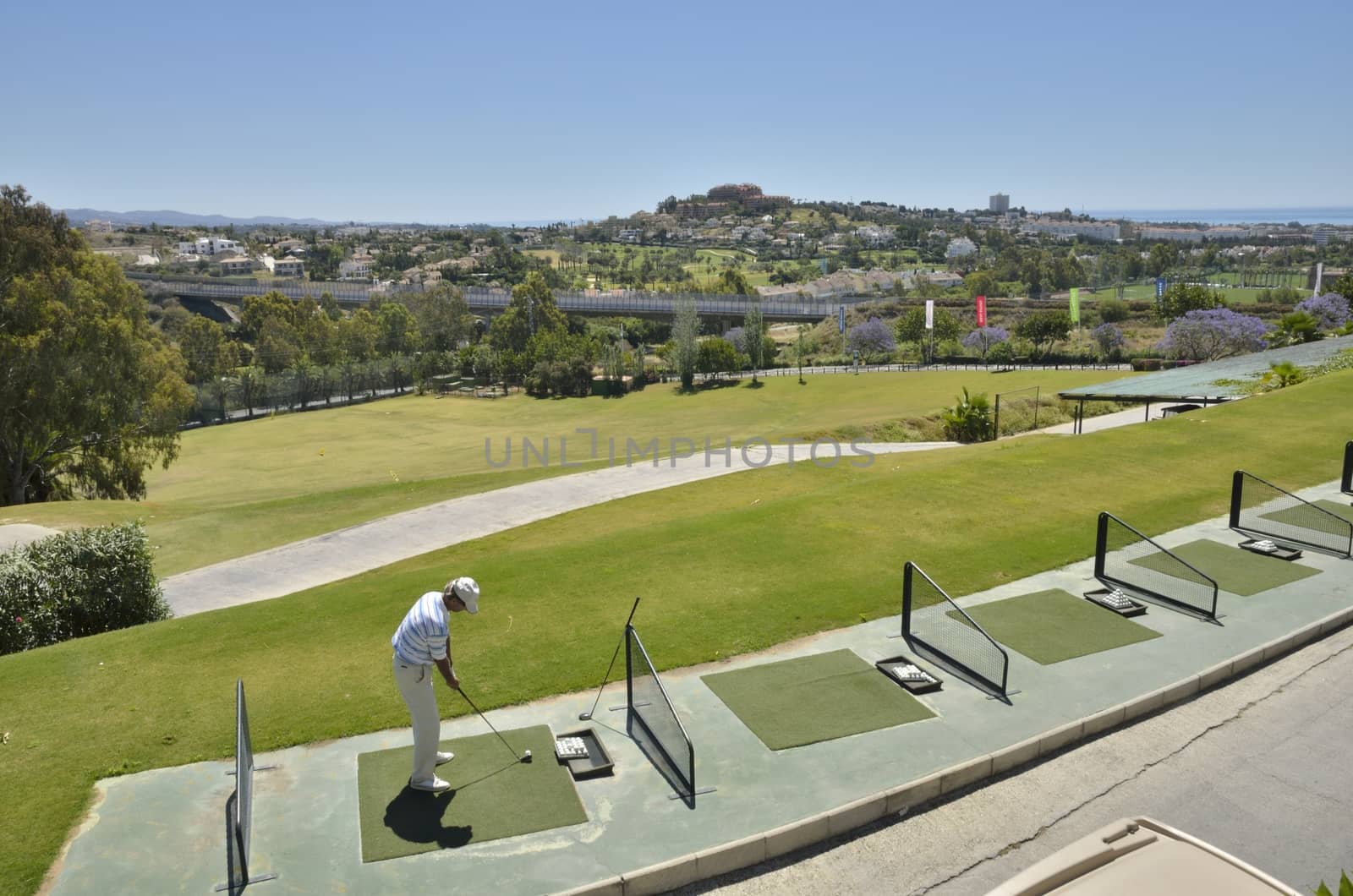 Man practicing golf swing in La Quinta golf, a golf course in Marbella, Spain.