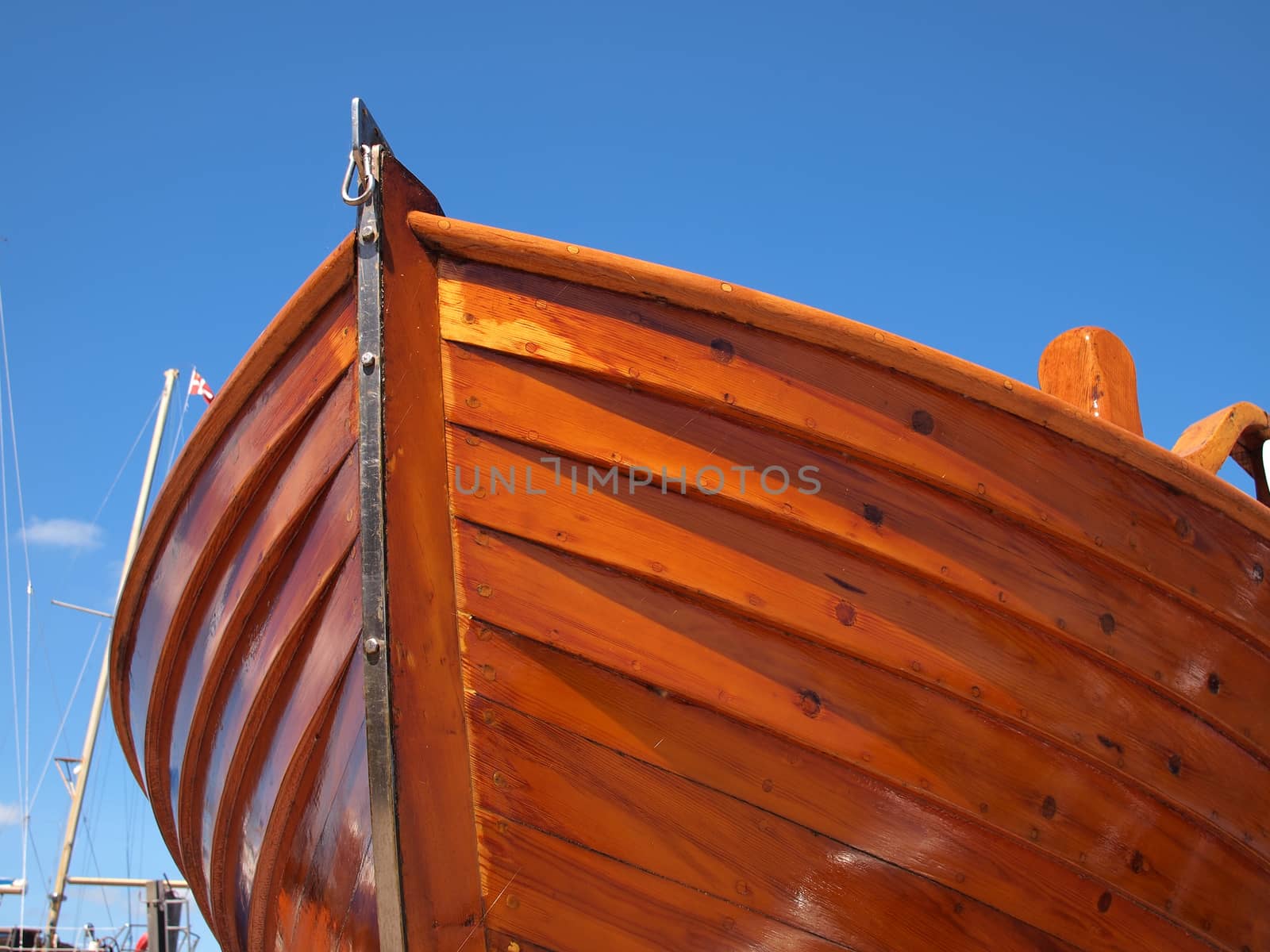 Prow of a small wooden boat with clear blue sky background      