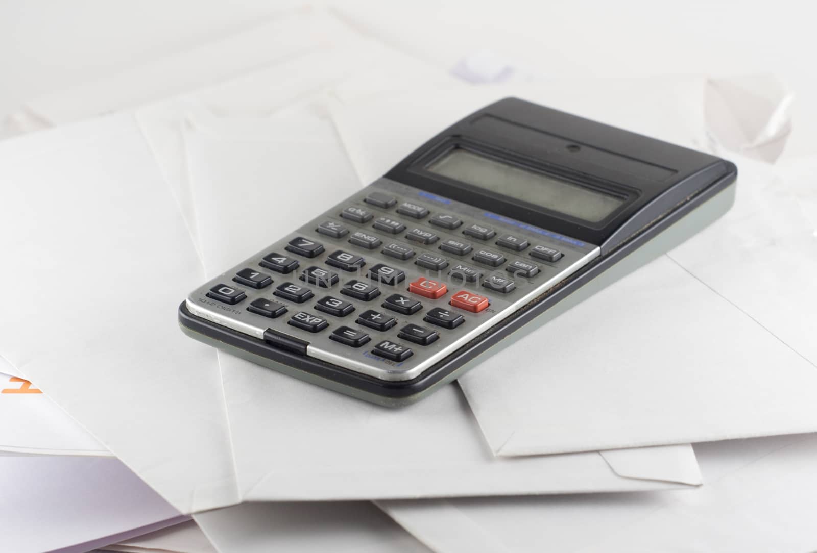 Calculator and white bills envelopes close up