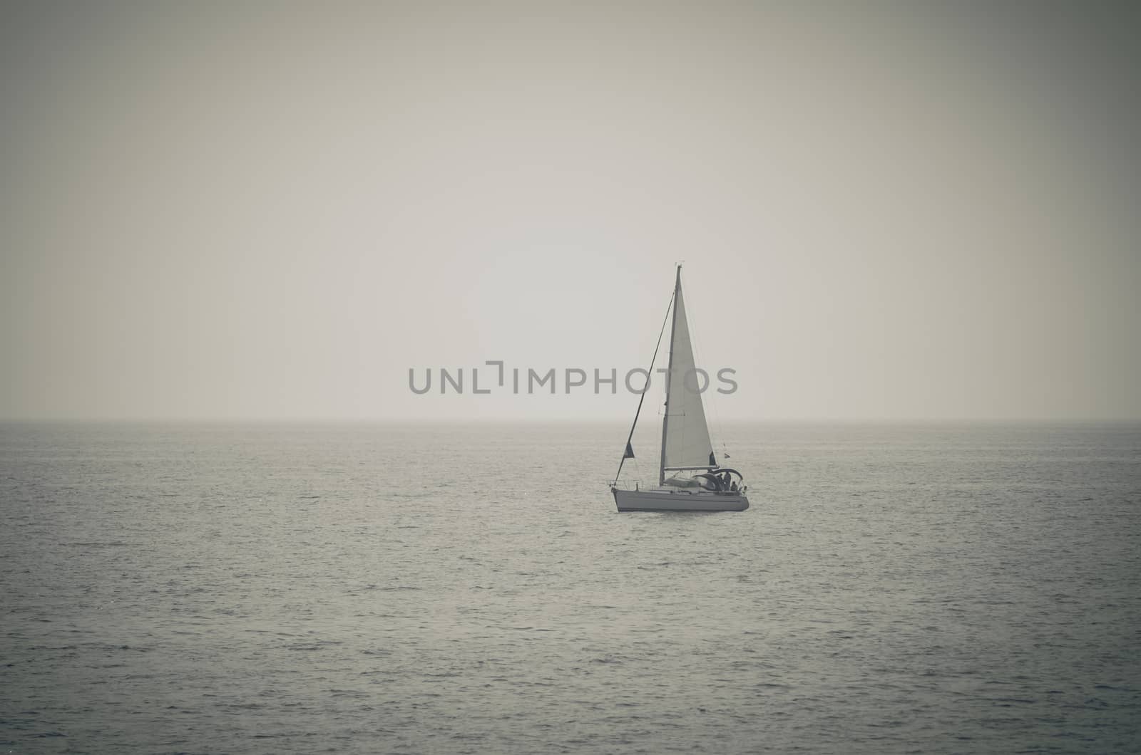 Retro toned  picture of yacht sailing on the sea by Lizard
