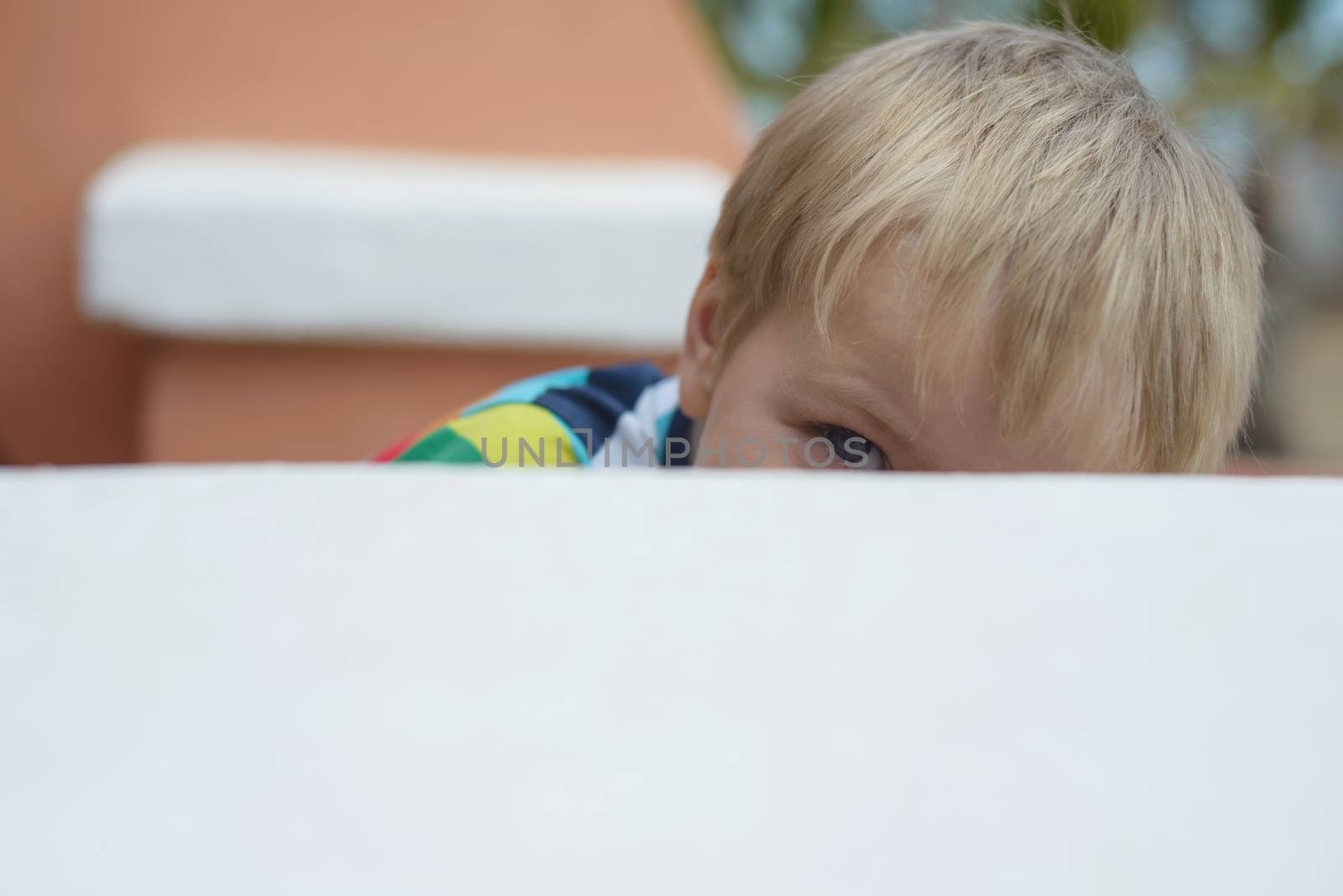 Prying little boy looking up onto wall