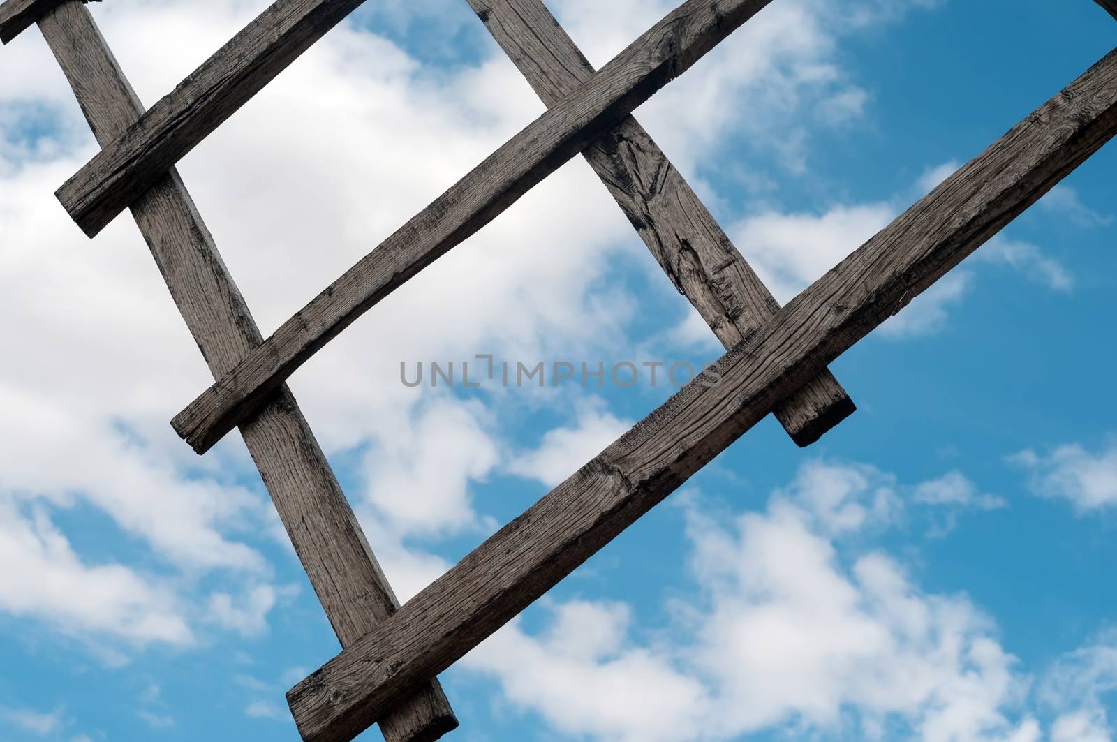 Wooden wing from old windmill over blue sky