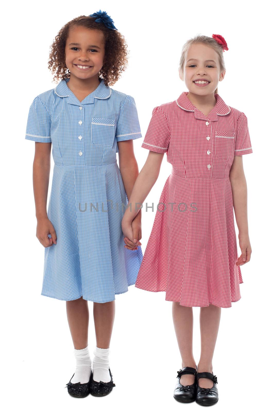Cheerful school girls posing together, holding hands