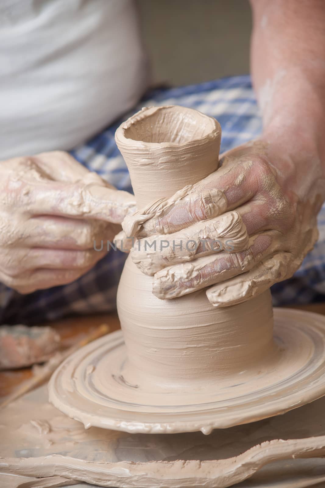 Hands of a potter, creating an earthen jar on the circle