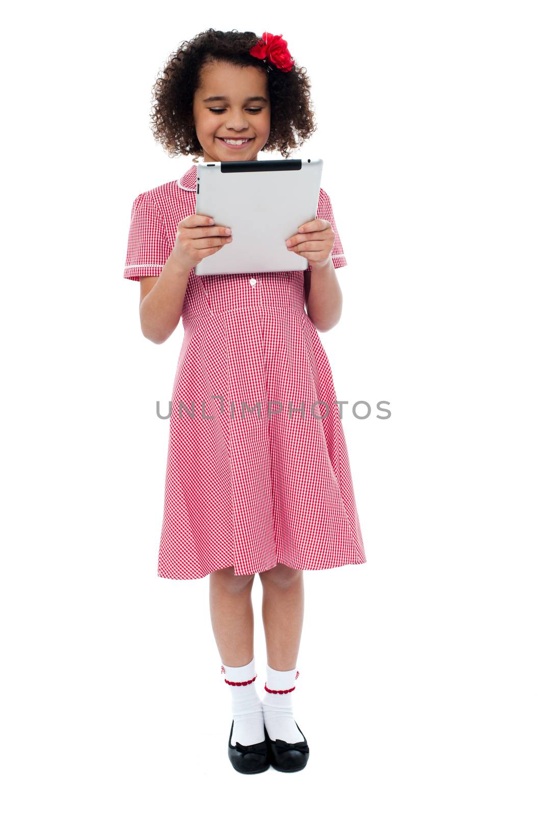Smiling child busy with tablet pc by stockyimages