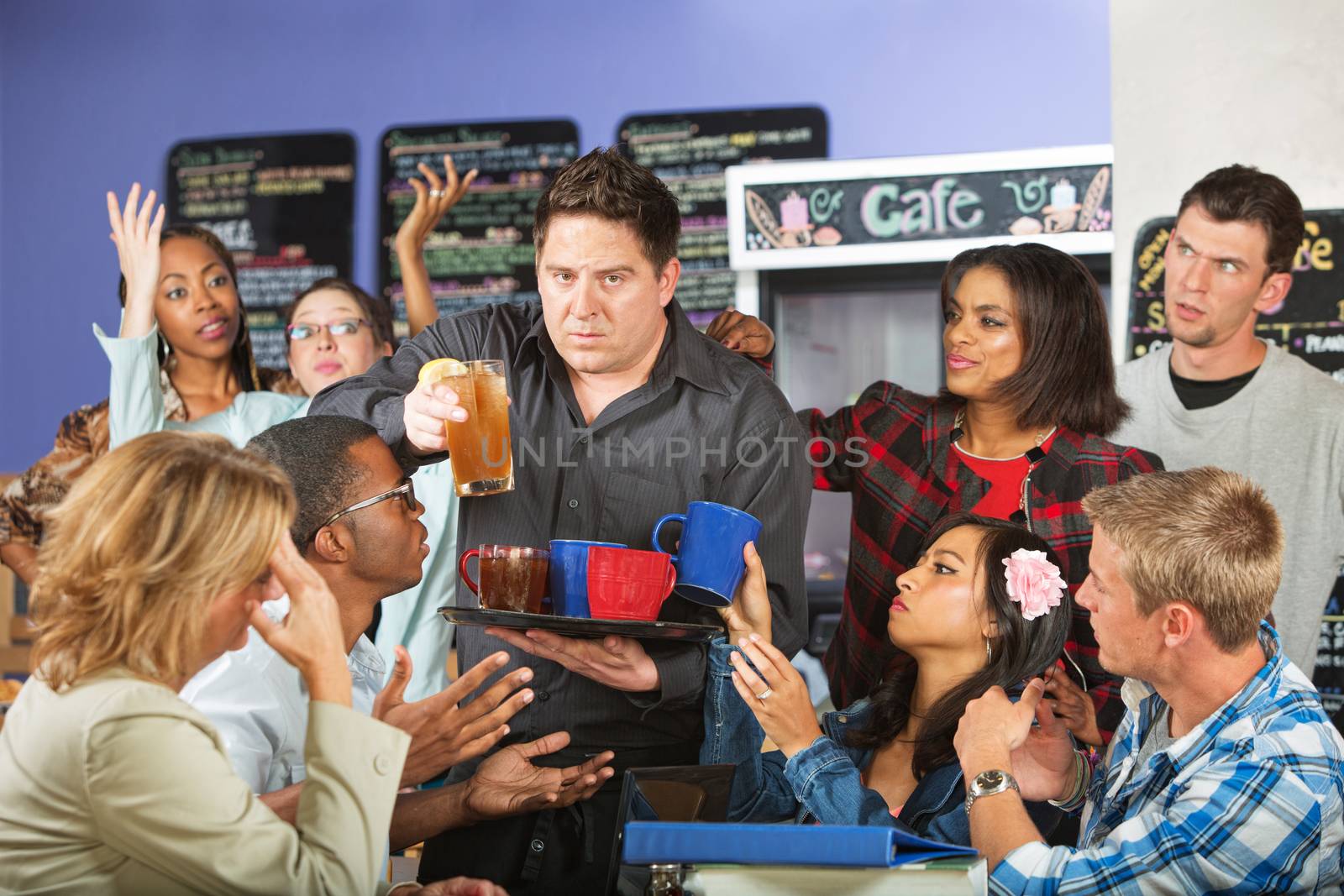 Stressed out restaurant waiter with group of angry customers