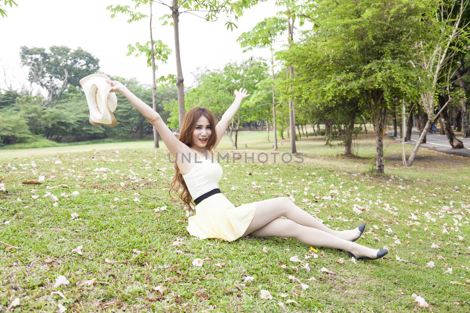 Woman sitting on the grass. In the park and the blossoms filled the yard.