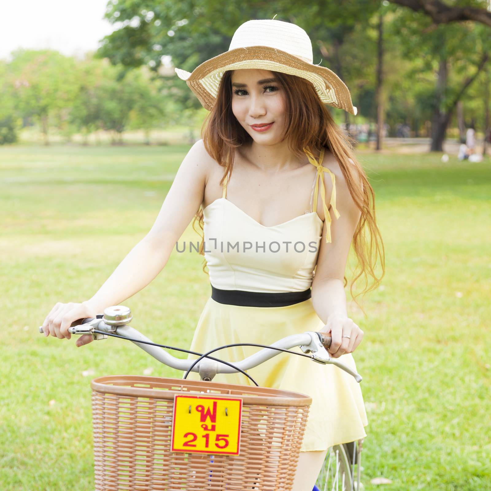 Asian woman riding a bicycle In the lawn in the park in the evening.
