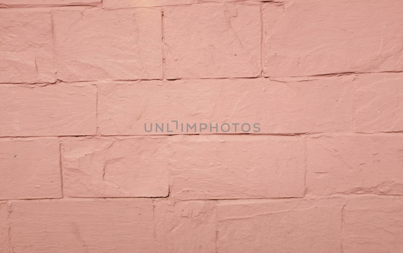 A pink painted rendered wall with embedded lines.