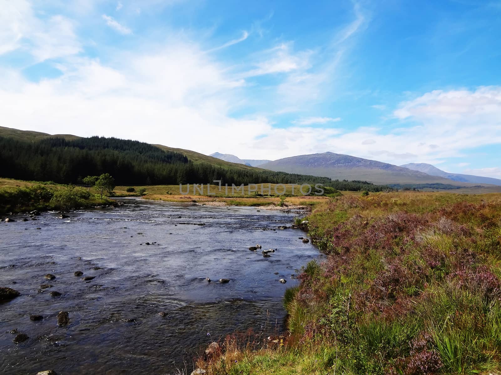 Scottish Highlands river in the mountains with blue sky