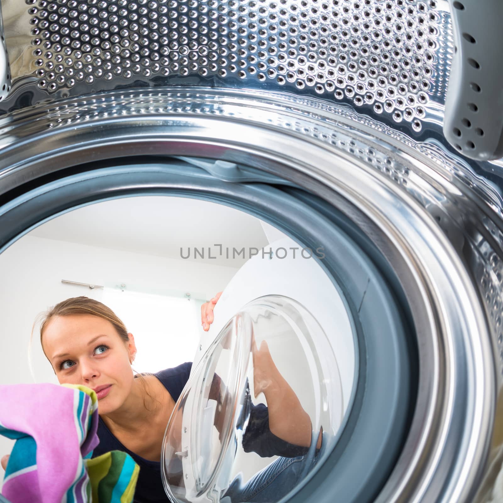 Housework: young woman doing laundry (shallow DOF; color toned image)