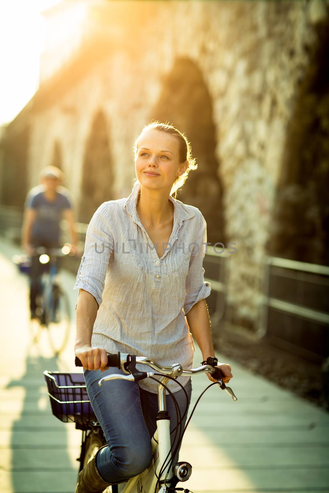 Pretty, young woman riding a bicycle in a city by viktor_cap