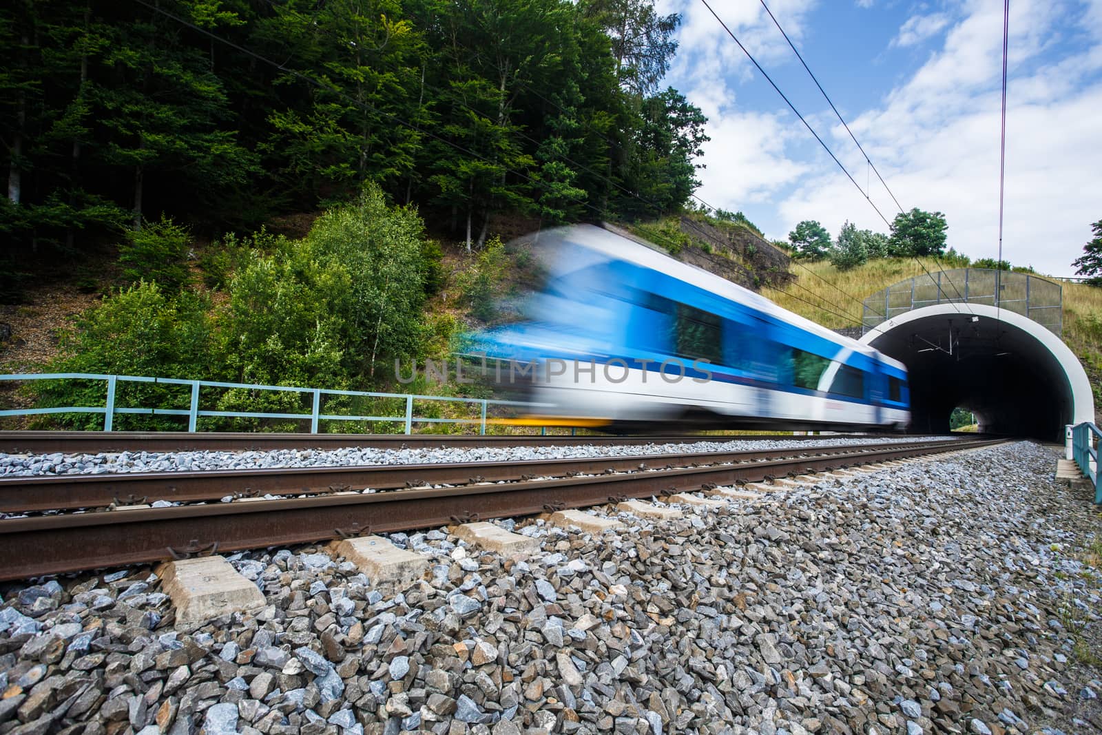 Fast train passing through a tunnel on a lovely summer day by viktor_cap