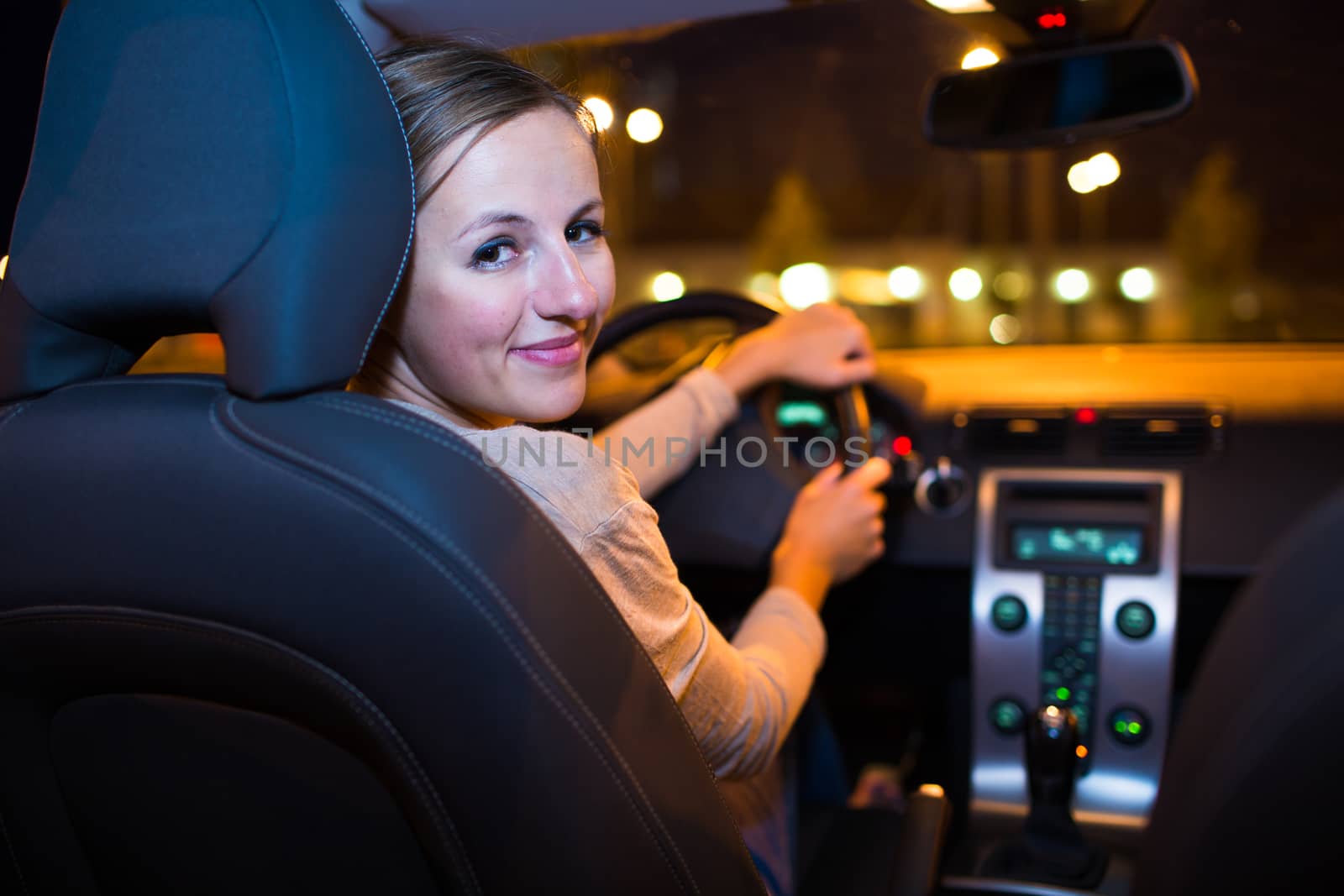 Pretty young woman driving her new car