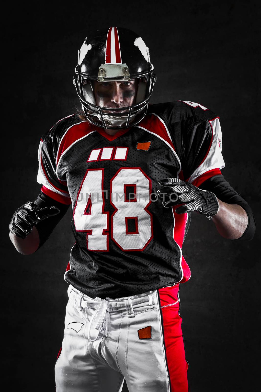 Portrait of american football player on dark background