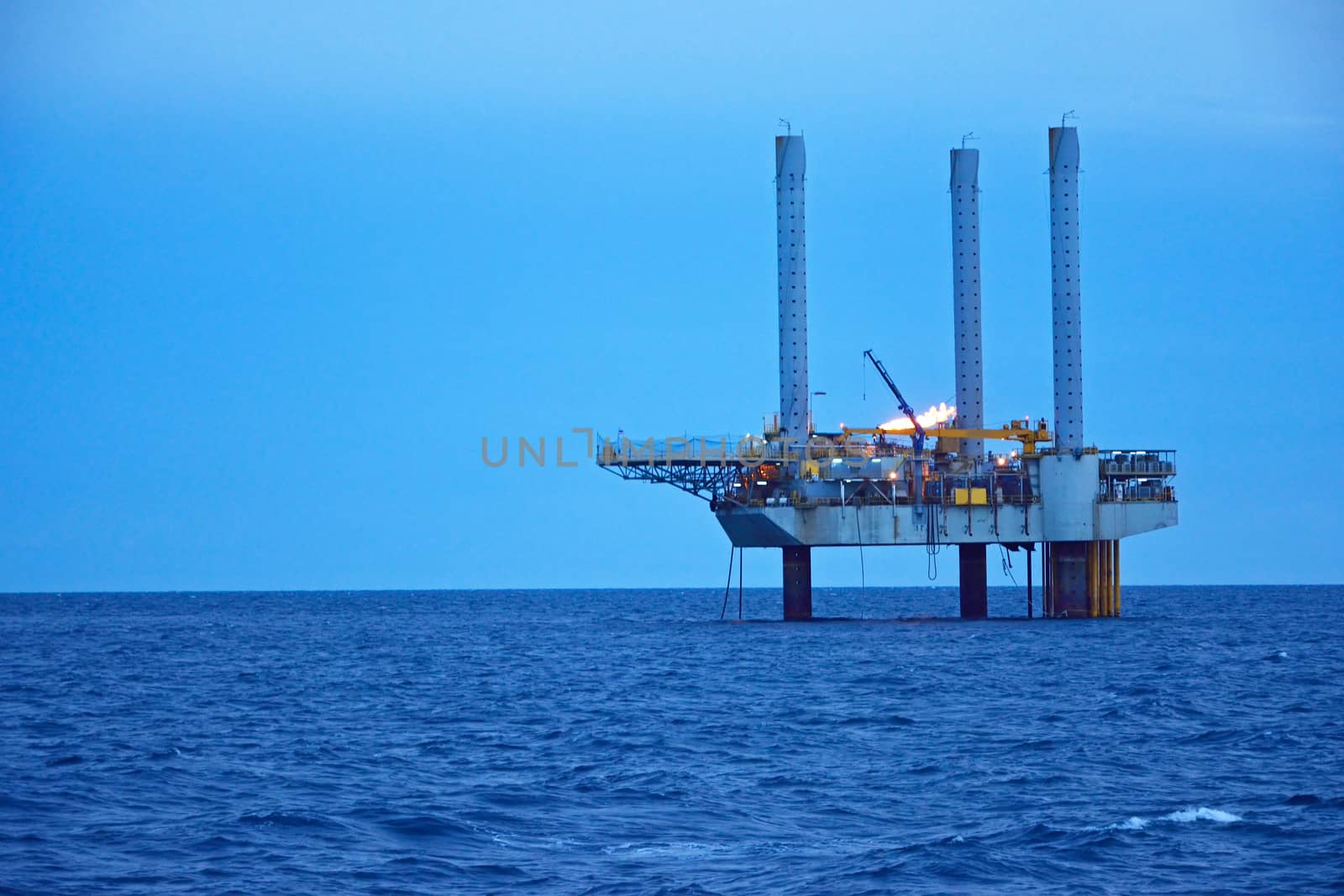 The offshore oil rig in early morning, Gulf of Thailand. by think4photop