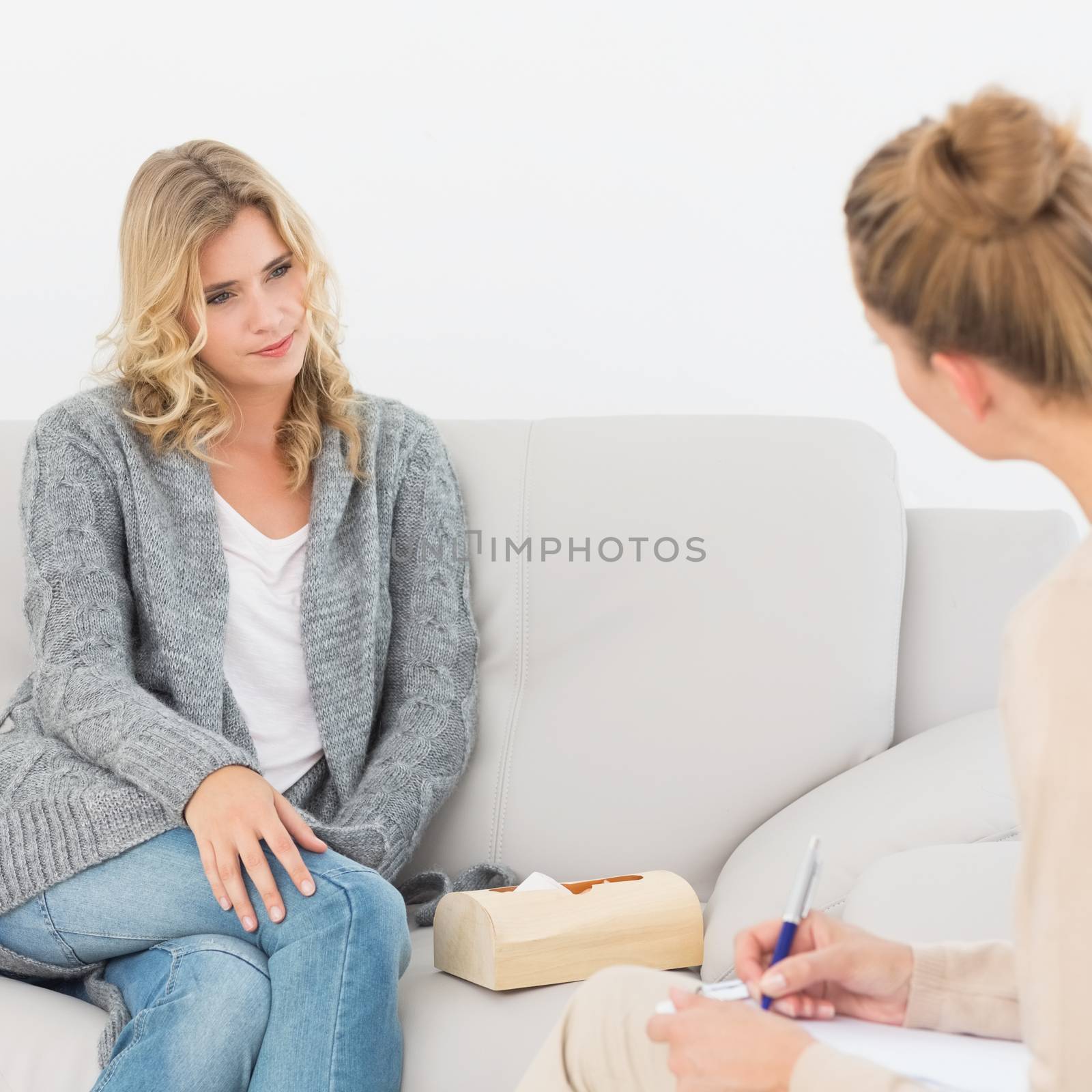 Blonde woman listening to her therapist at therapy session