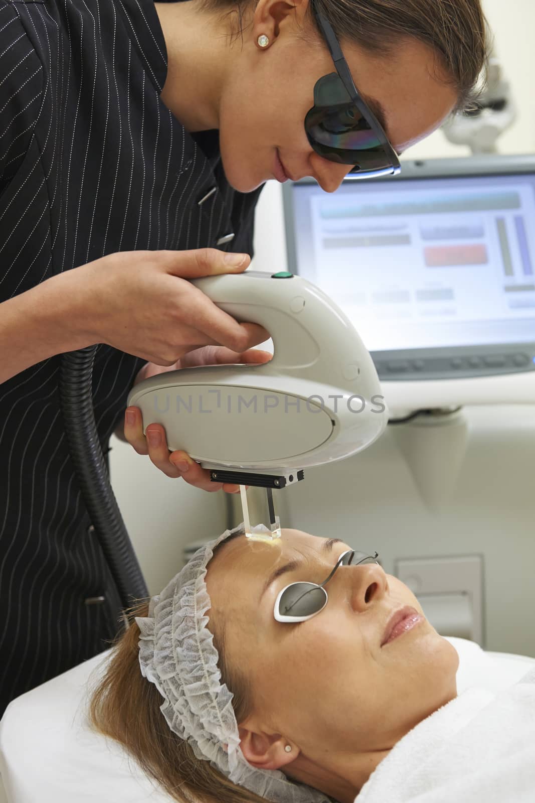 Beautician Carrying Out Fractional Laser Treatment by HighwayStarz