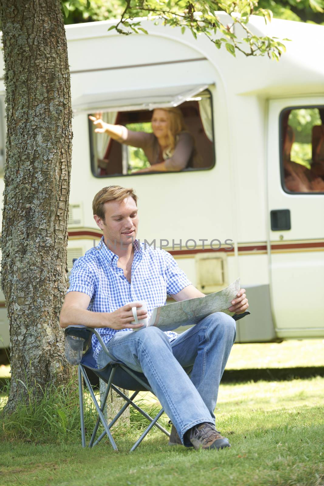 Man Relaxing Outside Mobile Home On Vacation by HighwayStarz