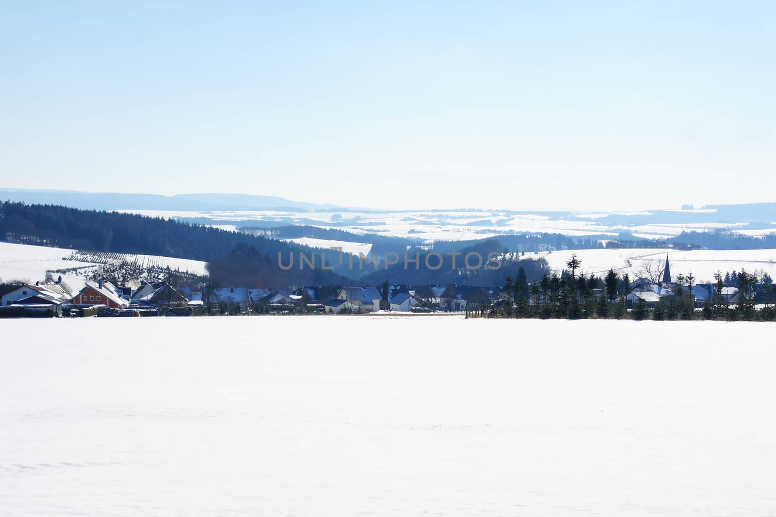 snowy Hunsrück with the Dhrontal and the village Heinzerath in the foreground