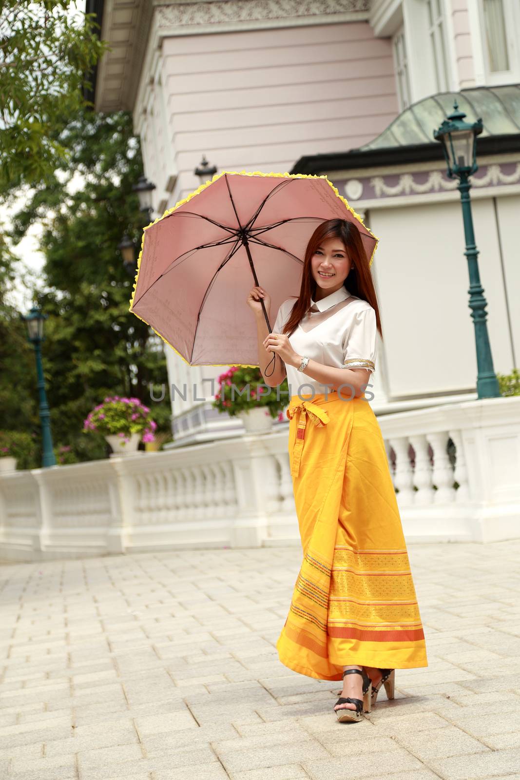 Thai girl dressing and umbrella with traditional style (palace background)
