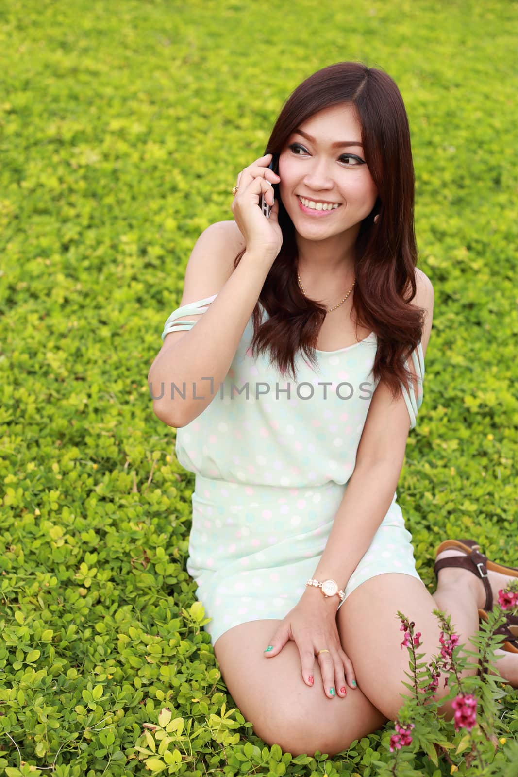 young smilling woman talking on a mobile in the garden