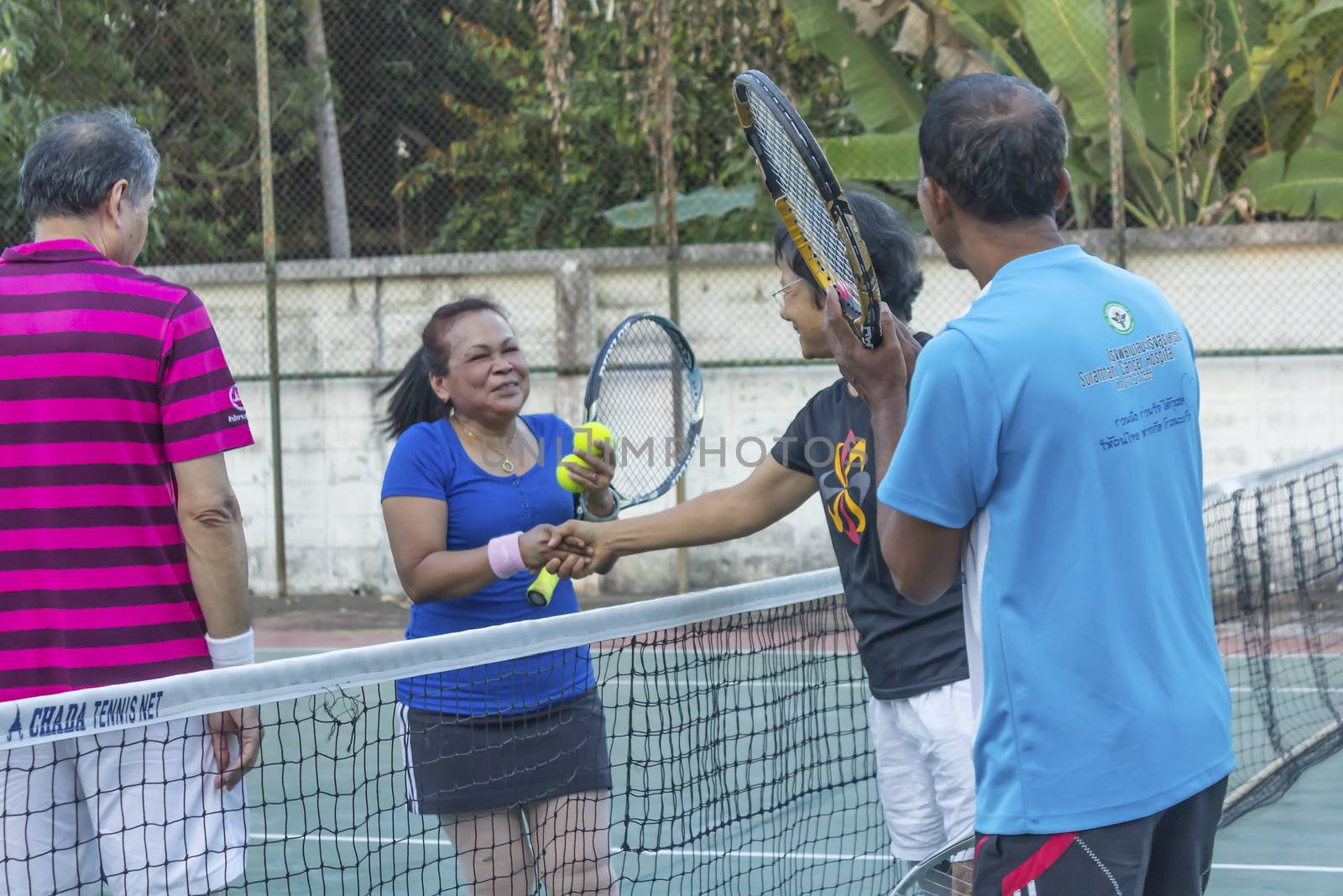 SURAT THANI, THAILAND - MARCH 1:Unidentified Thai senior tennis players shakes the hands after winning the match on March 1, 2014 in Chaiya tennis court, Surat Thani, Thailand.