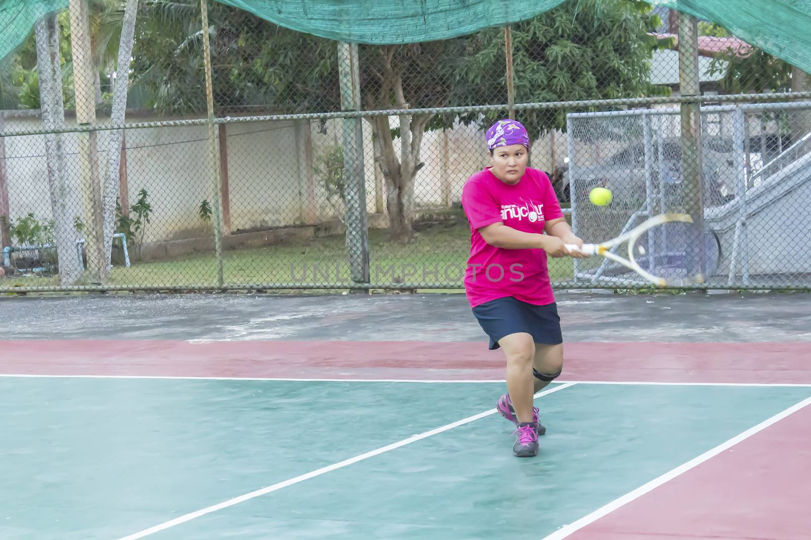 SURAT THANI, THAILAND - MARCH 1:Unidentified Thai senior woman play tennis outdoor at Chaiya tennis court on March 1, 2014 in Surat Thani, Thailand.