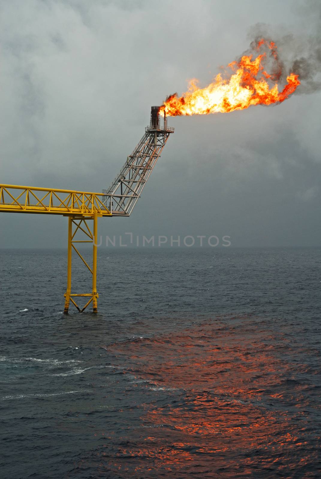 Flare boom nozzle and fire on offshore oil rig by think4photop