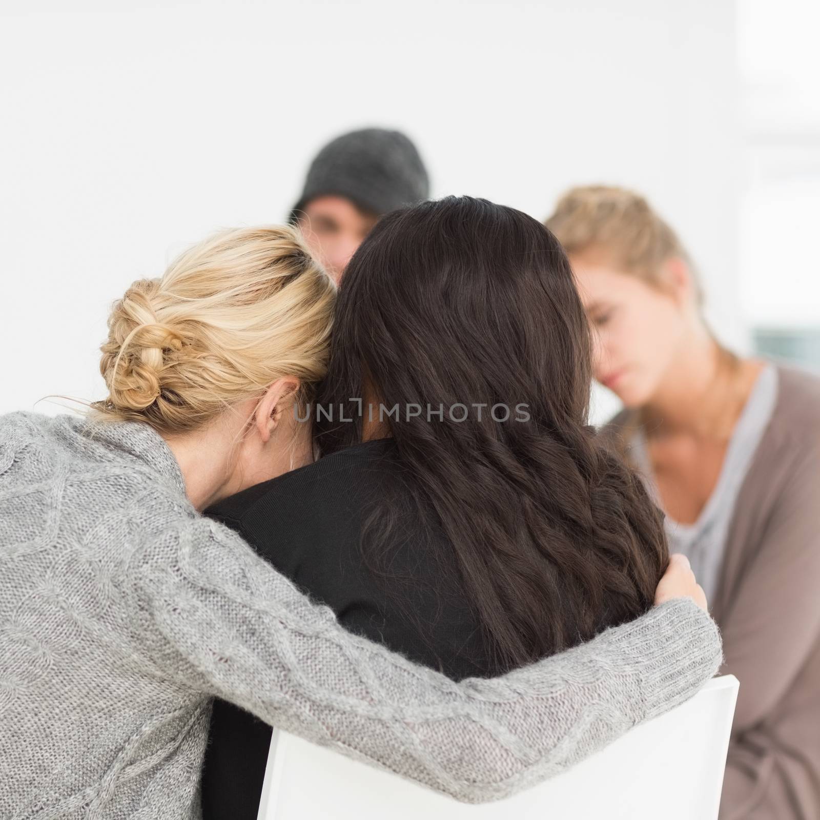 Women hugging in rehab group at therapy session